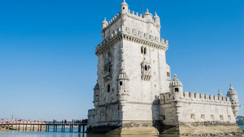 Torre de Belém em Lisboa em um dia ensolarado com céu azul refletindo na água