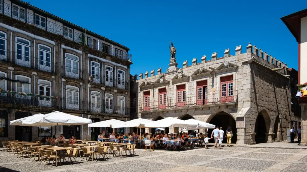 Praça de São Tiago e Antigos Paços do Concelho com esplanadas de restaurantes em Guimarães.