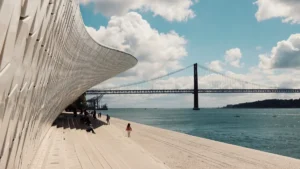 Fachada em azulejos do museu MAAT em Lisboa a beira do Rio Tejo com a Ponte 25 de Abril ao fundo