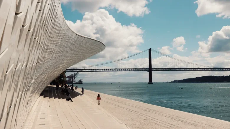Fachada em azulejos do museu MAAT em Lisboa a beira do Rio Tejo com a Ponte 25 de Abril ao fundo