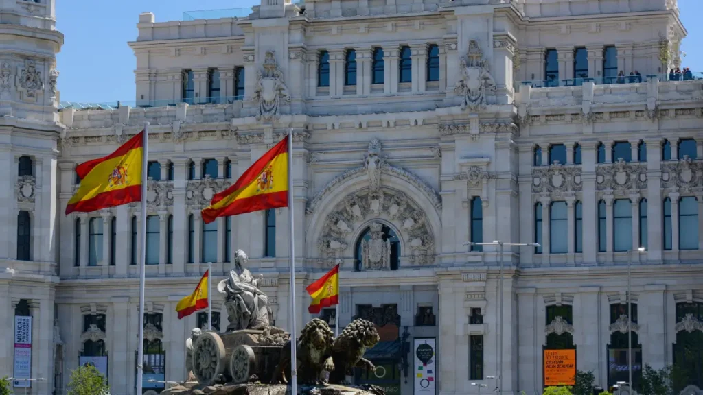 Palacio de Cibeles e Fuente de Cibeles com bandeiras ao viajar sozinha para espanha 40 anos
