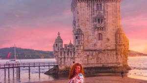 Viajante solo em frente à Torre de Belém ao pôr do sol em seu roteiro em Belem Lisboa