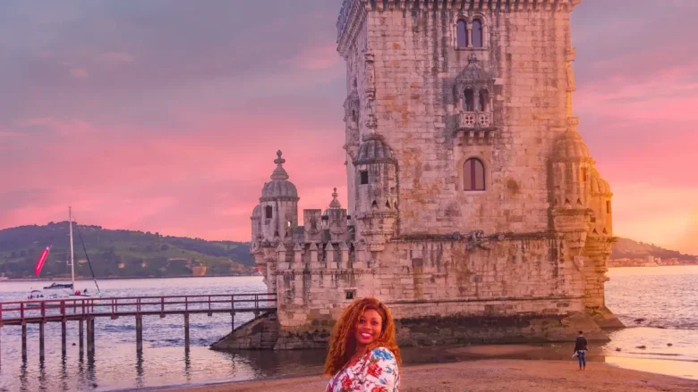 Viajante solo em frente à Torre de Belém ao pôr do sol em seu roteiro em Belem Lisboa