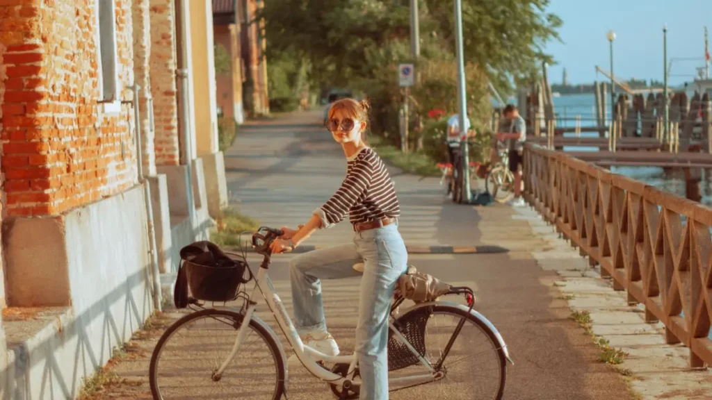 Mulher aproveitando um passeio de bicicleta ao ar livre em um destino europeu durante sua viagem solo feminina aos 40.